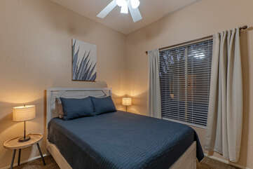 On the ground floor is Bedroom 5 with a queen bed, ceiling fan and TV.