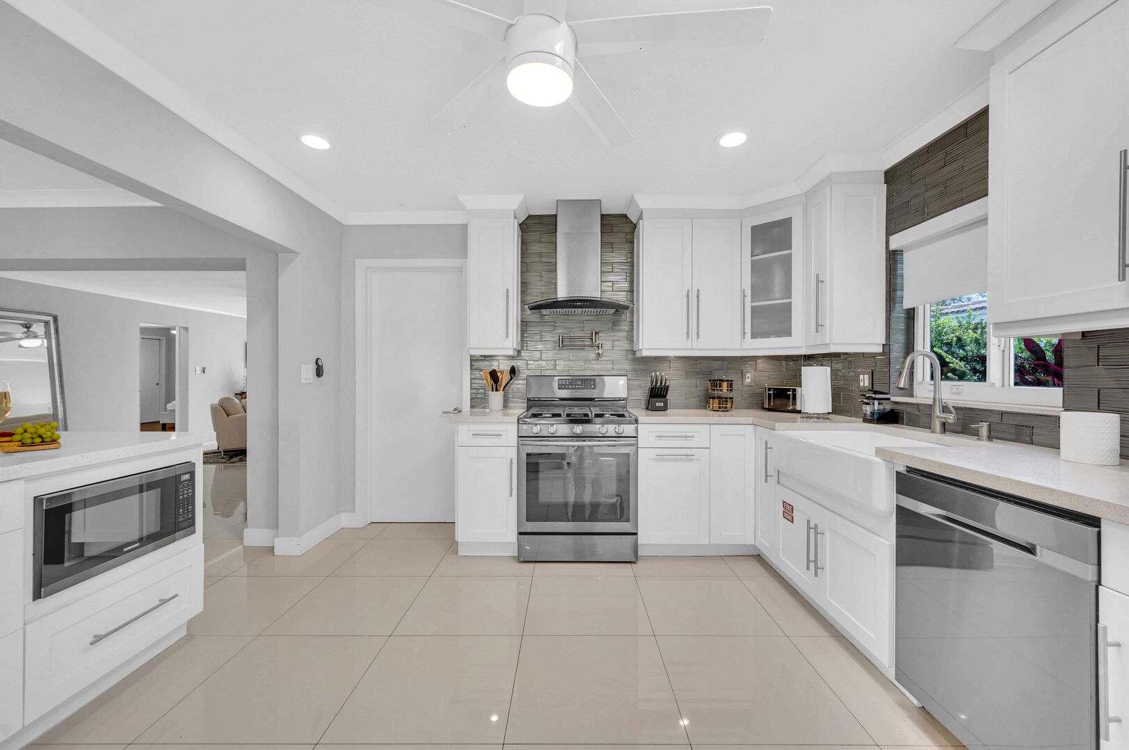 The large open kitchen is equipped with state of the art appliances for every gourmet chef. Extra counter space and a perfect view of the living room, dining room, and backyard oasis.