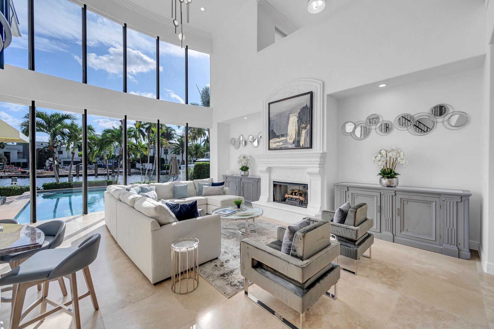 The living room offers a view of the waterfront and the heated swimming pool.