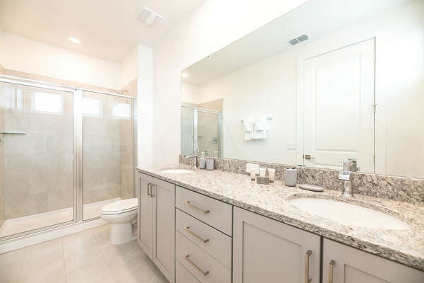 The en suite bathroom has a dual vanity and walk-in shower