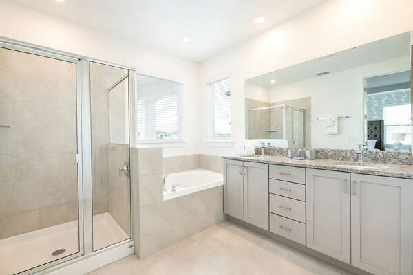 The en suite bathroom has a dual vanity, walk-in shower, and garden tub