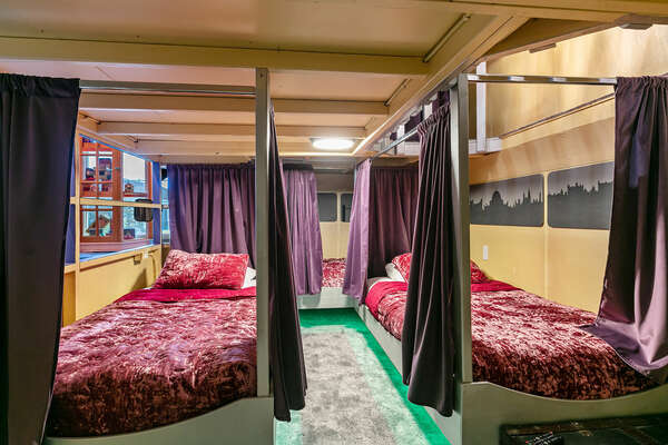 The double decker bus has 2 twin beds on the upper level and 3 twin beds on the bottom