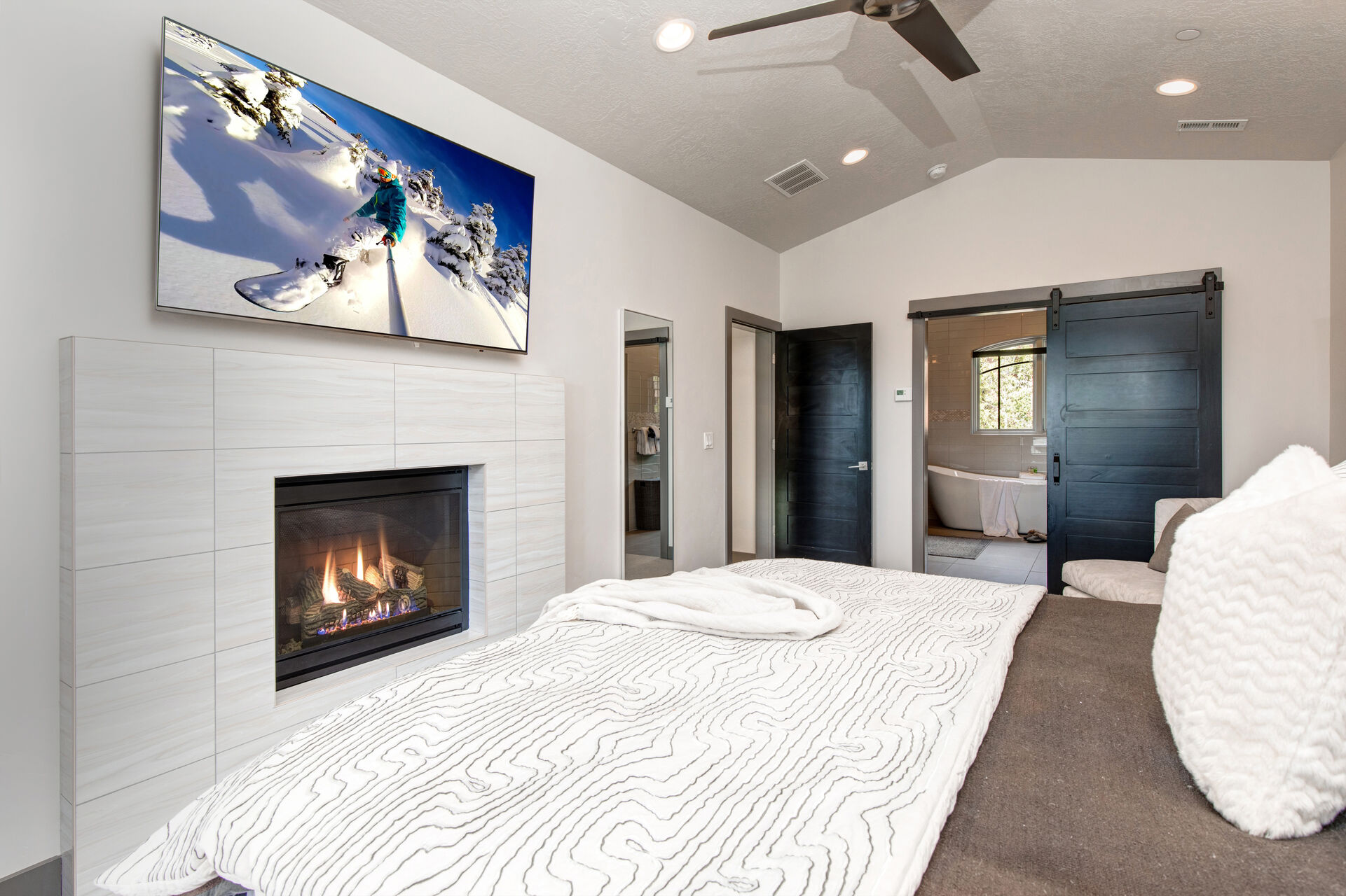 Upper Level Master Bedroom with king bed, gas fireplace, smart TV, private patio, and en suite bathroom