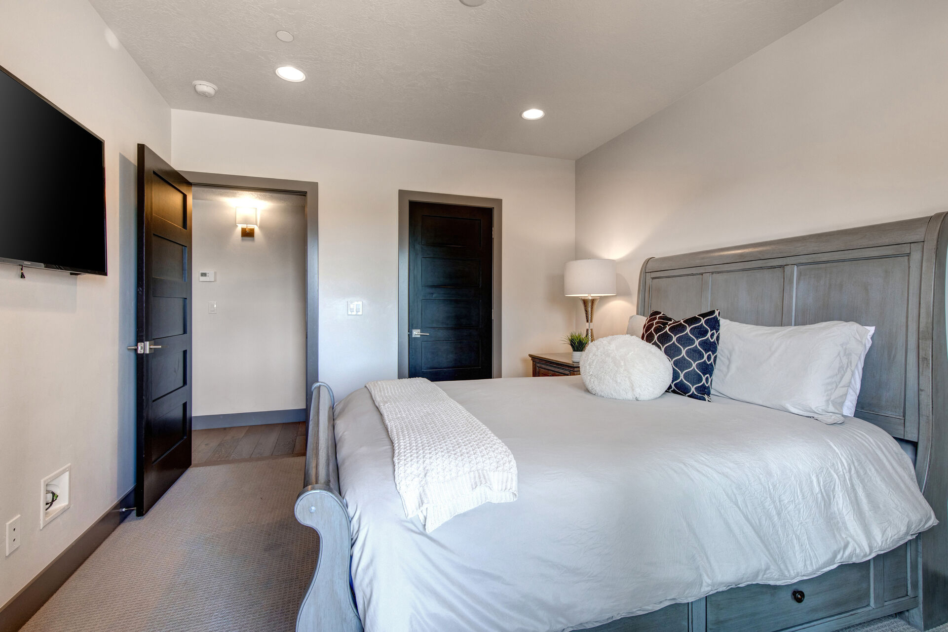 Lower Level Bedroom 2 with queen bed, smart tv, access to private hot tub patio, and full bath access