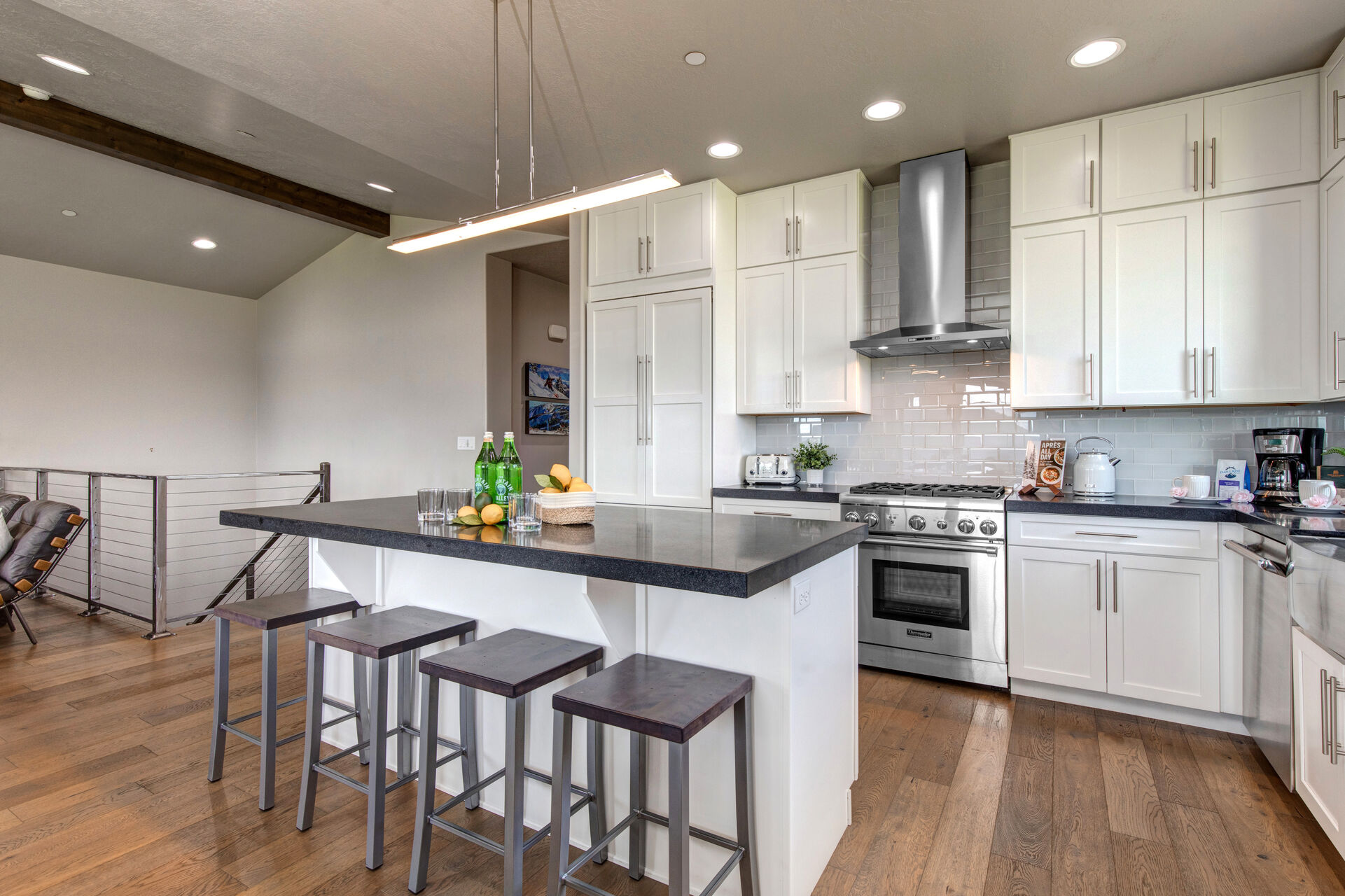 Fully Equipped Kitchen with gorgeous quartz countertops, stainless steel Thermadore appliances, beautiful hardwood floors and bar seating for four