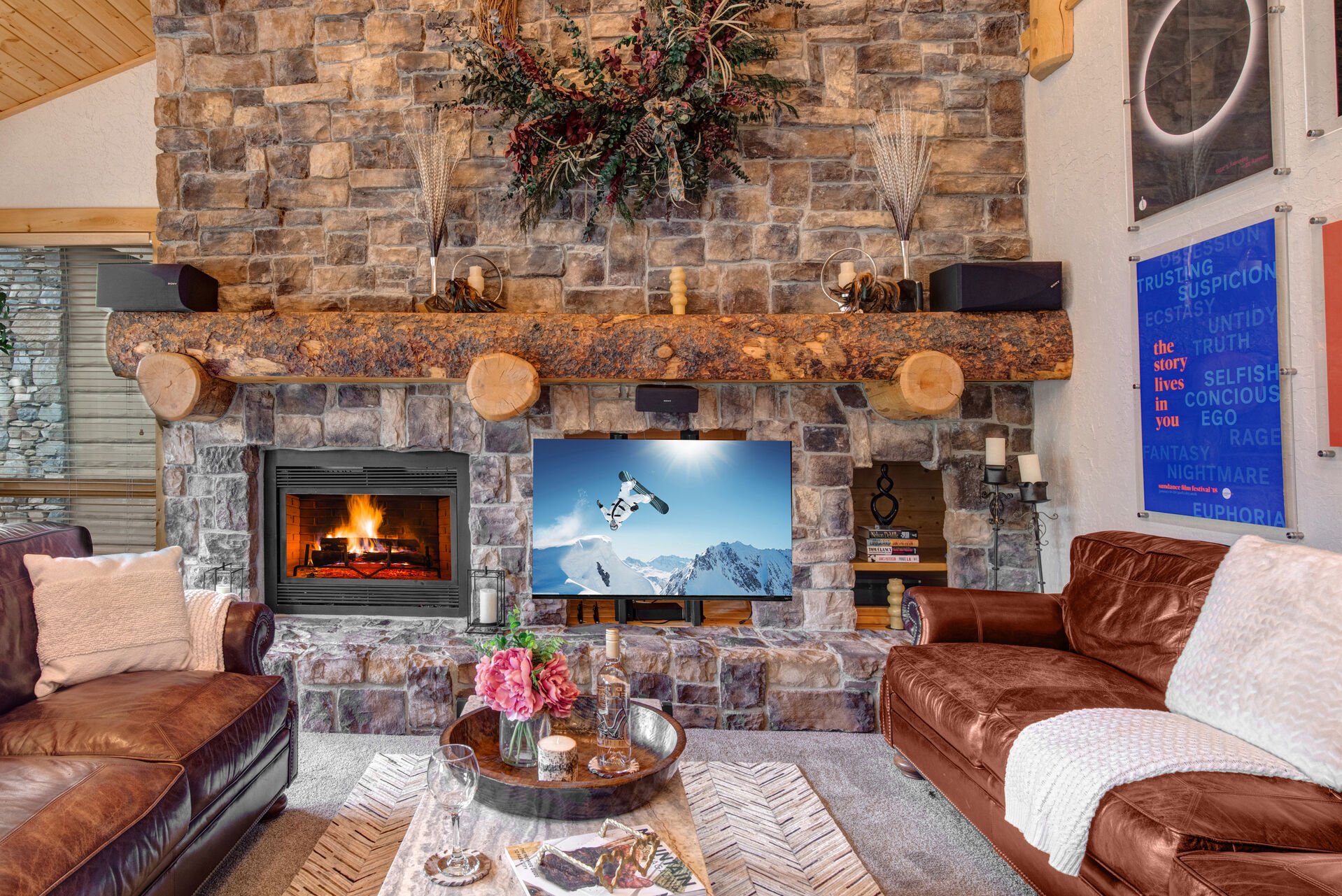 Main Level Living Room with plush leather sofas, contemporary arm chairs, smart tv, gas fireplace, vaulted ceilings, and private hot tub patio access
