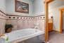Master Bathroom with double sinks, jetted tub, and tile & glass shower
