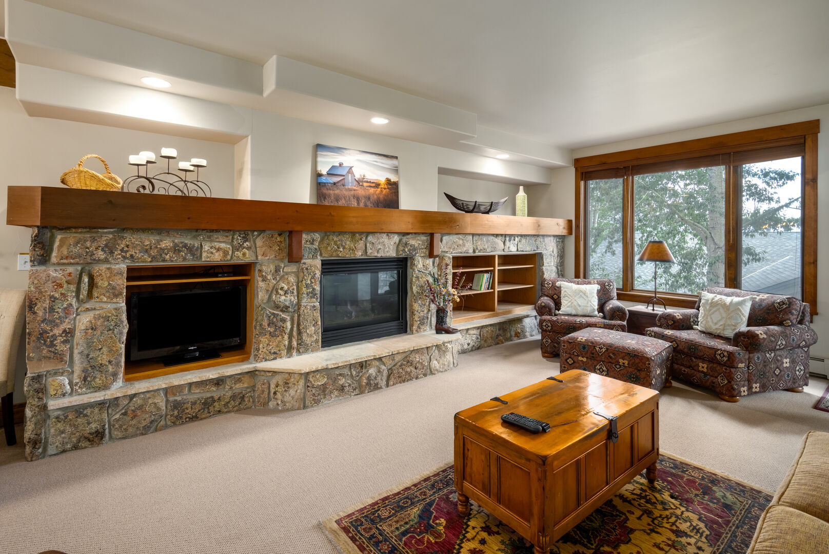 Large main level living space with gas fireplace and stacked rock wall.