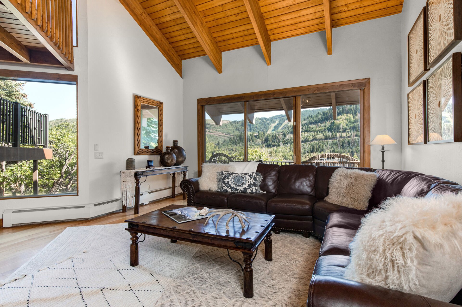 Main Living Room with plush, over-sized leather sectional, gas fireplace, smart TV, and private deck access