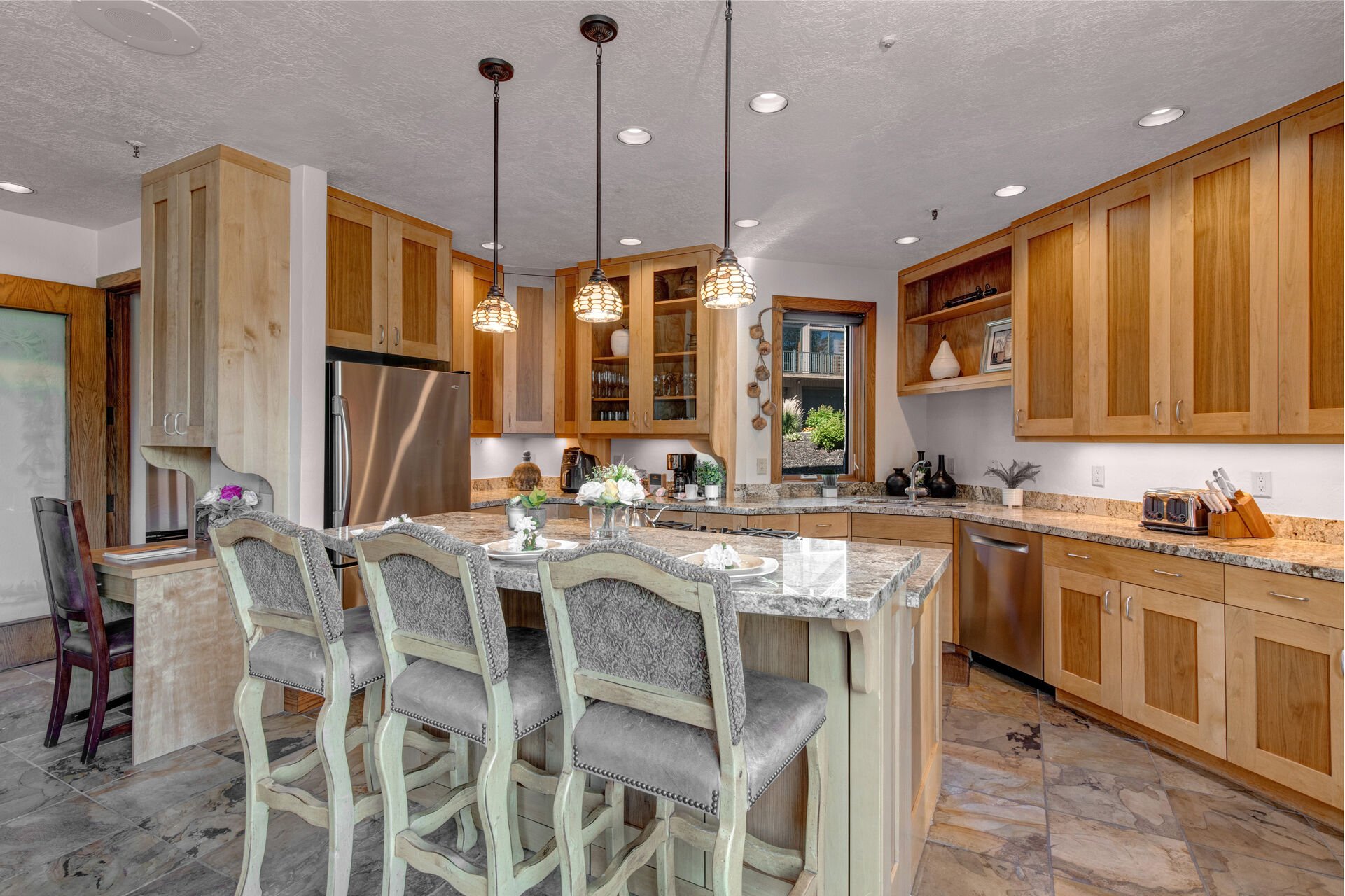 Fully Equipped Kitchen with gorgeous stone countertops, stainless steel appliances, private deck access, and island seating for 3