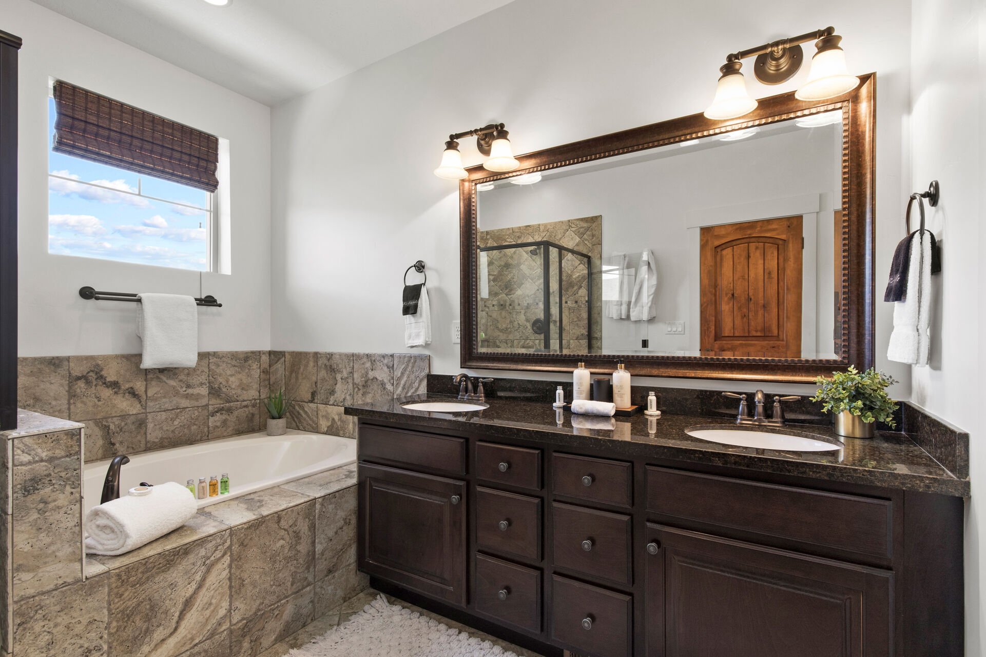 Master Bathroom with double sinks, soaking tub, and large tile & glass shower