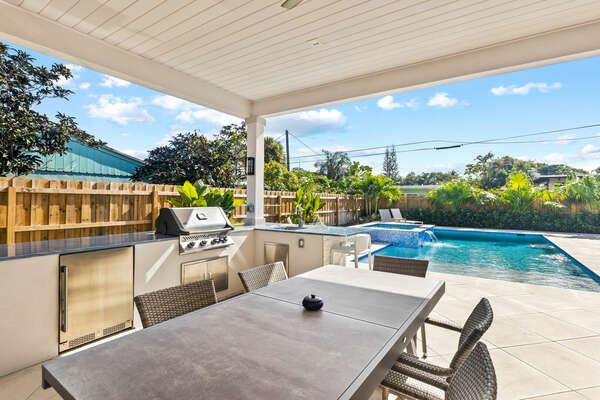 Outdoor dining with shade, fans, Florida kitchen.