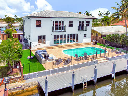 This large family home located directly on the water has a heated pool, boat dock and open plan living spaces.