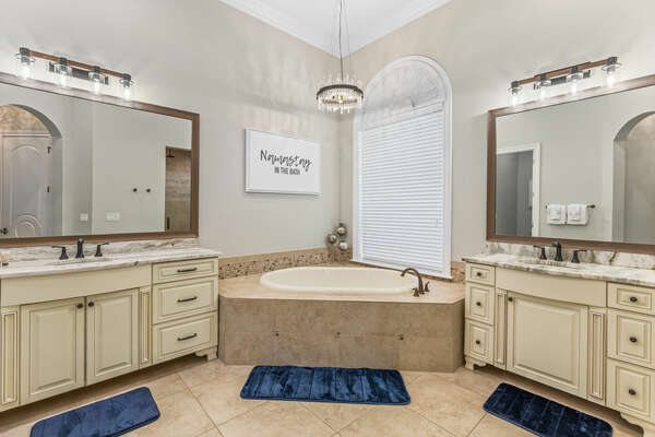 The master en-suite bathroom features his and hers vanity, garden tub, and walk-in shower