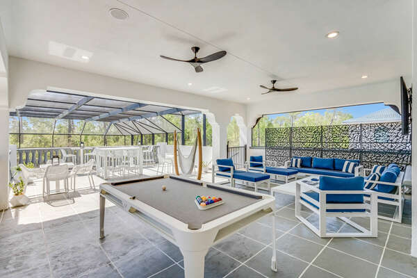 A gathering area on the balcony with a SMART TV with privacy shades, pool table, shuffle board and foosball