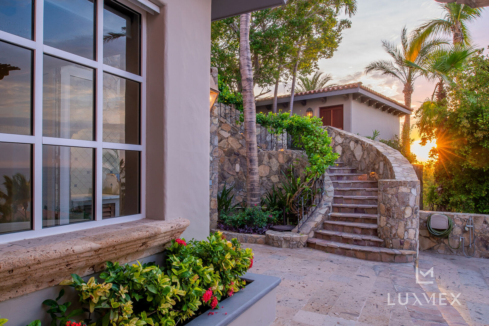 An entrance into the Los Cabos Luxury Vacation Villa; a stairway surrounded by tropical flora.