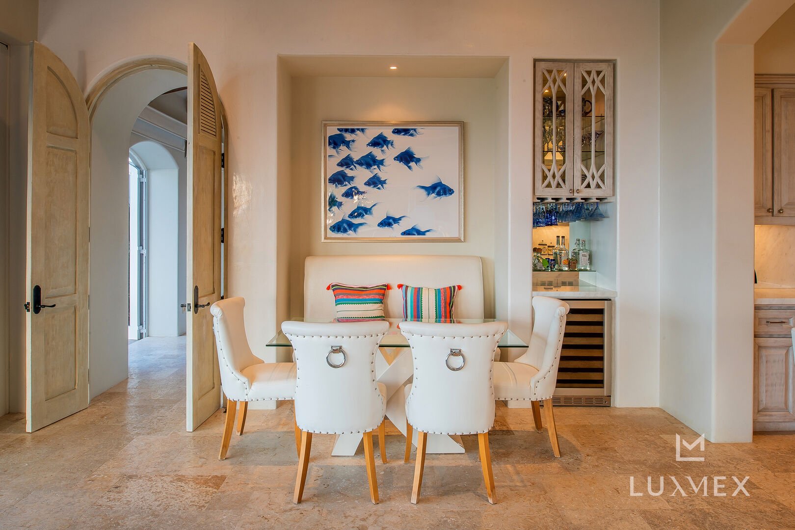 The dining table of Casita 6 sits below a painting of fish on a white background.