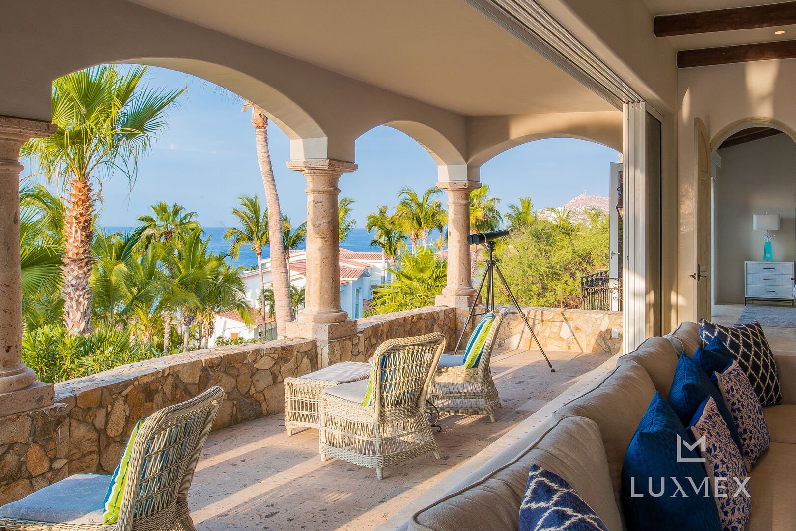 One of the patios of this Los Cabos Luxury Vacation Villa, with a telescope and patio chairs.