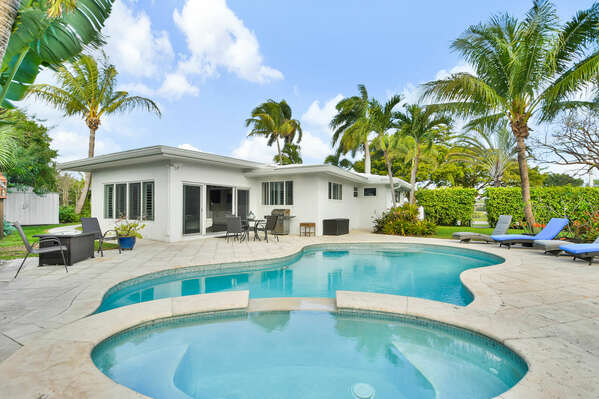 Quality family home, enticing yard with Heated pool, spa tub, outdoor dining and tropical planting.