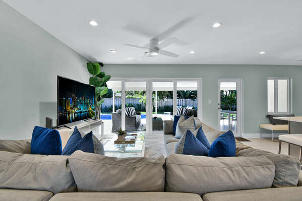 Family sofa with view of the pool and patio doors that open onto the yard