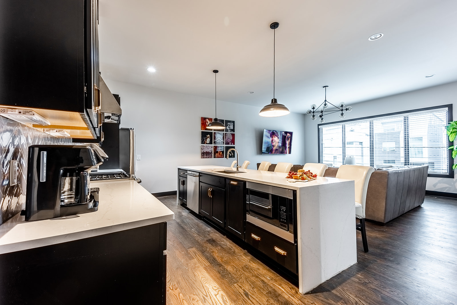 Unit 1: Fully equipped Kitchen with stainless steel appliances and breakfast bar seating.