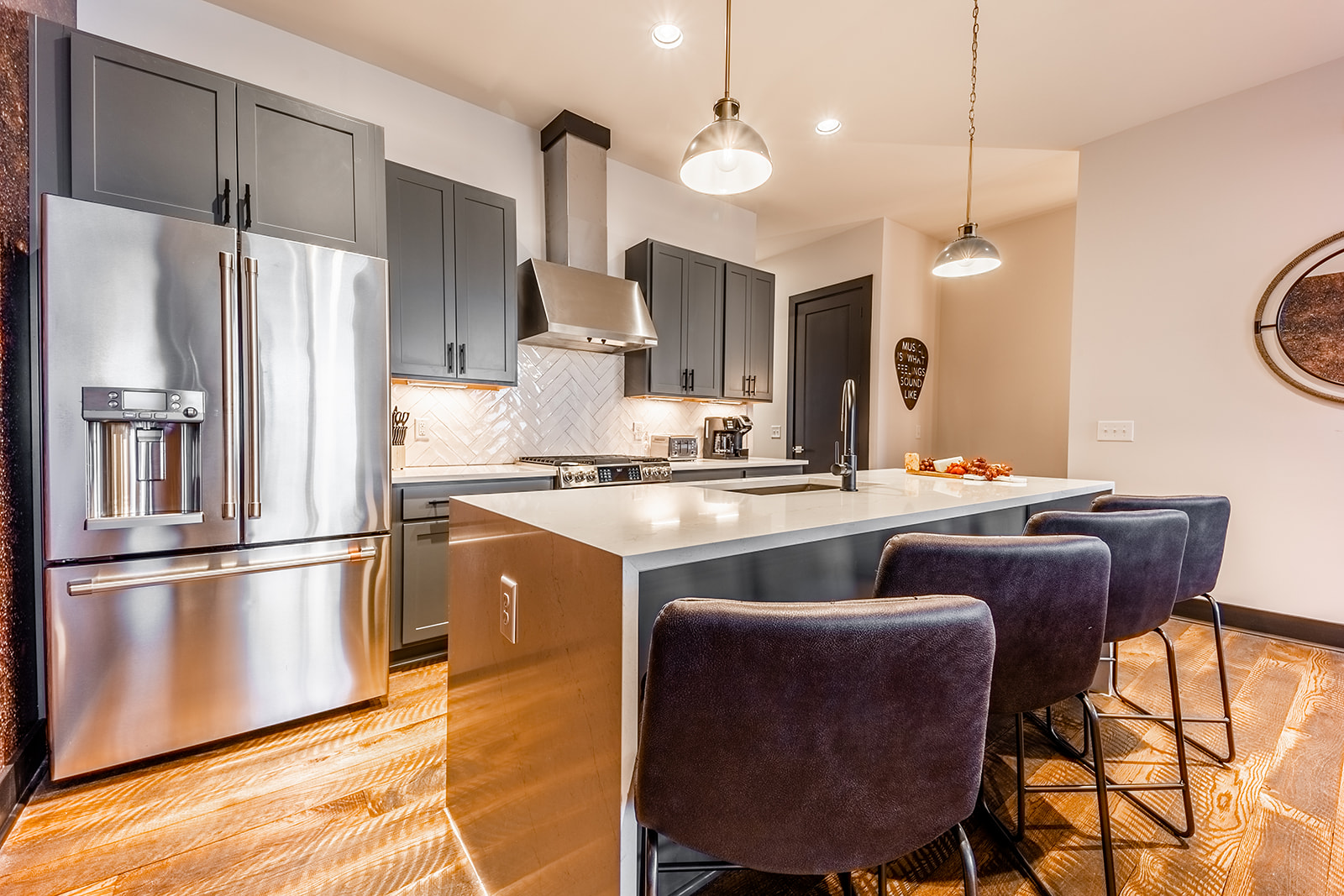 Unit 2: Fully equipped kitchen with stainless steel appliances and breakfast bar seating complete with bar stools.