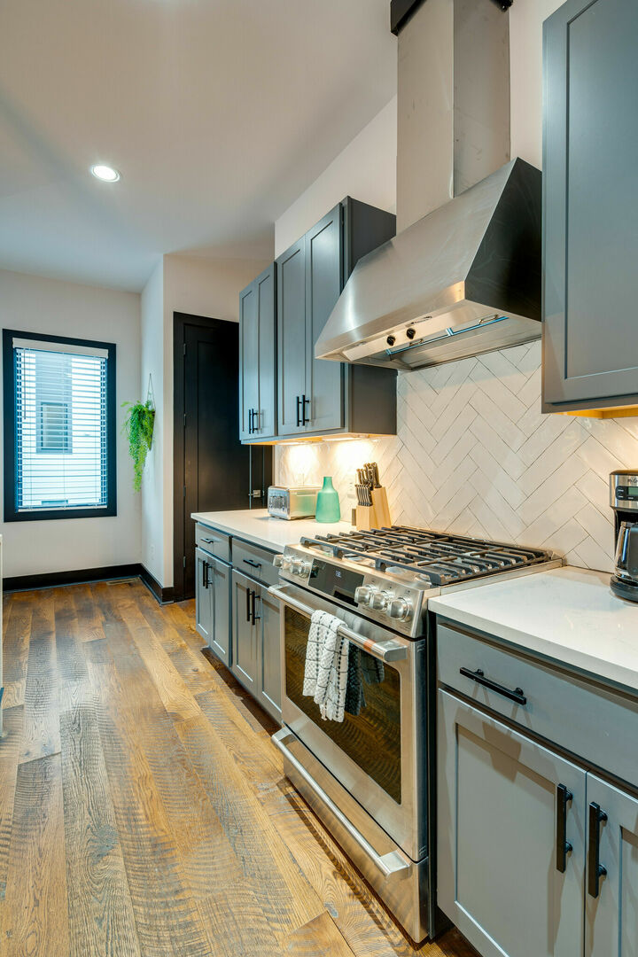 Unit 3: Fully equipped kitchen with stainless steel appliances, breakfast bar seating, and bar stools.