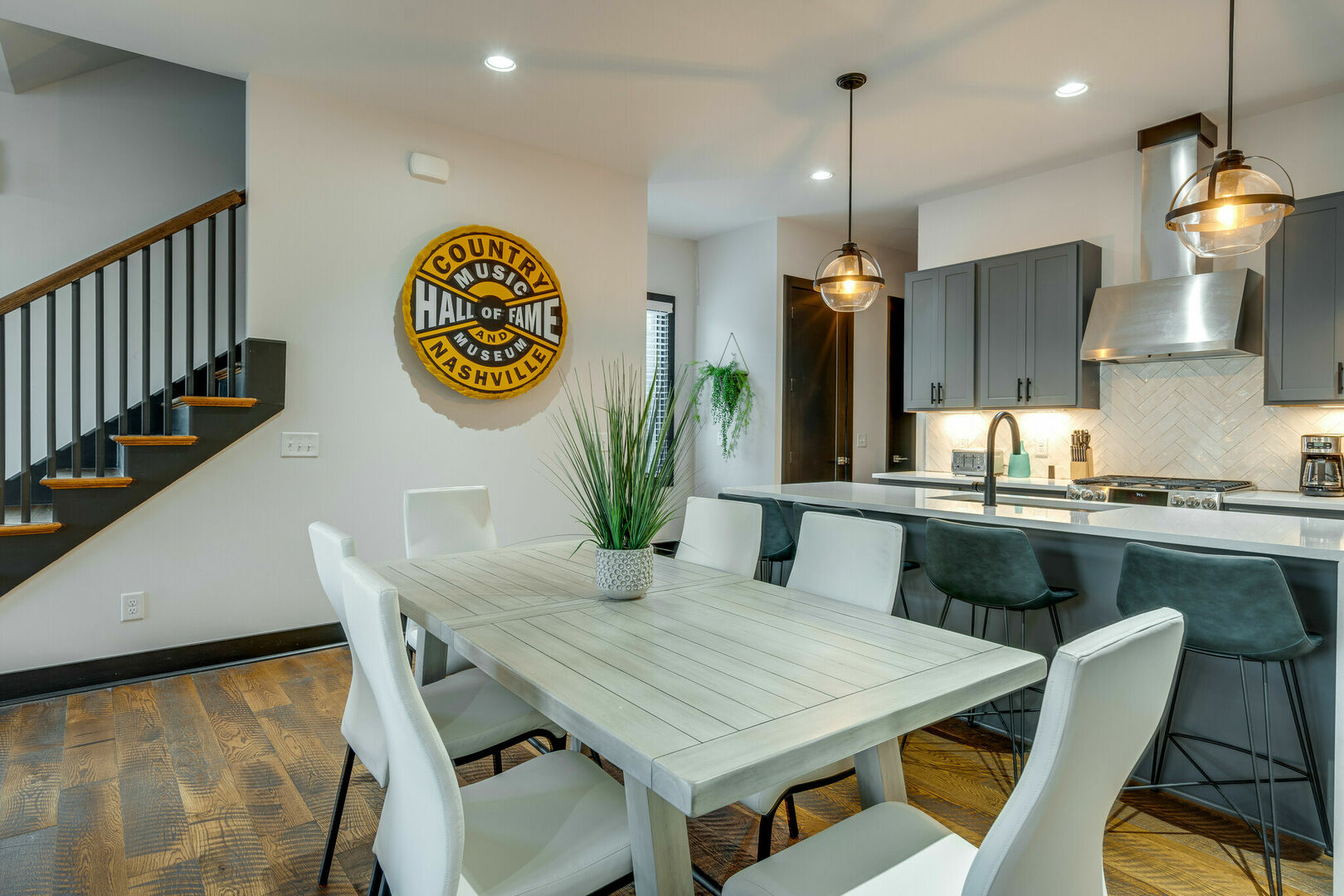 Unit 3: Fully equipped kitchen with stainless steel appliances, breakfast bar seating, and bar stools.