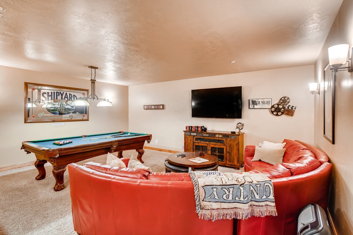 Lower Level Game/Theatre Room with over-sized leather sectional, smart TV, games, DVDs, full-sized billiards table, and full bar with fridge