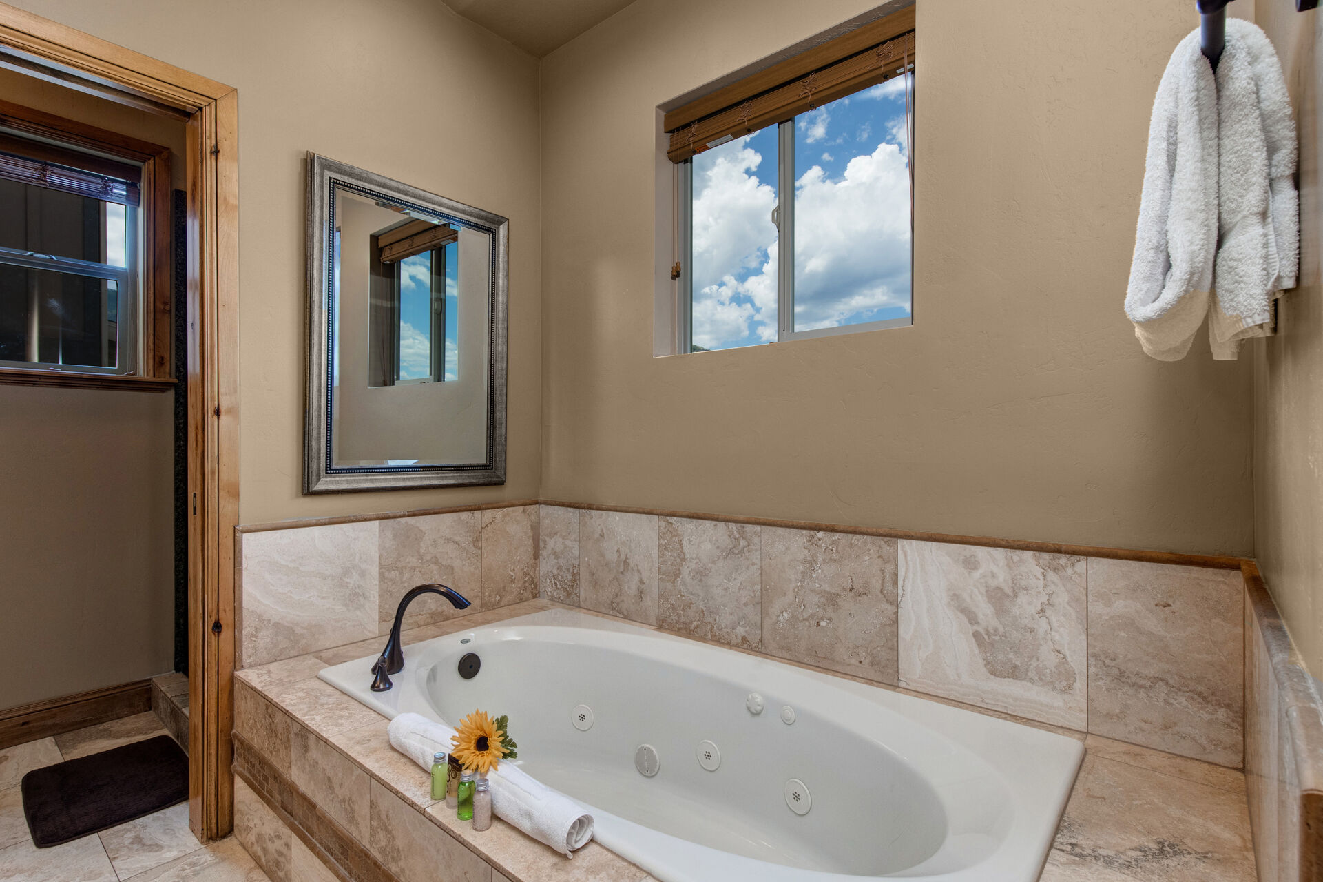 Master Bathroom with dual vanities, jetted soaking tub, and large glass and tile shower