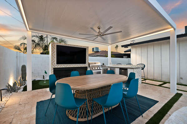 Outside dining with kitchen and entertainment.