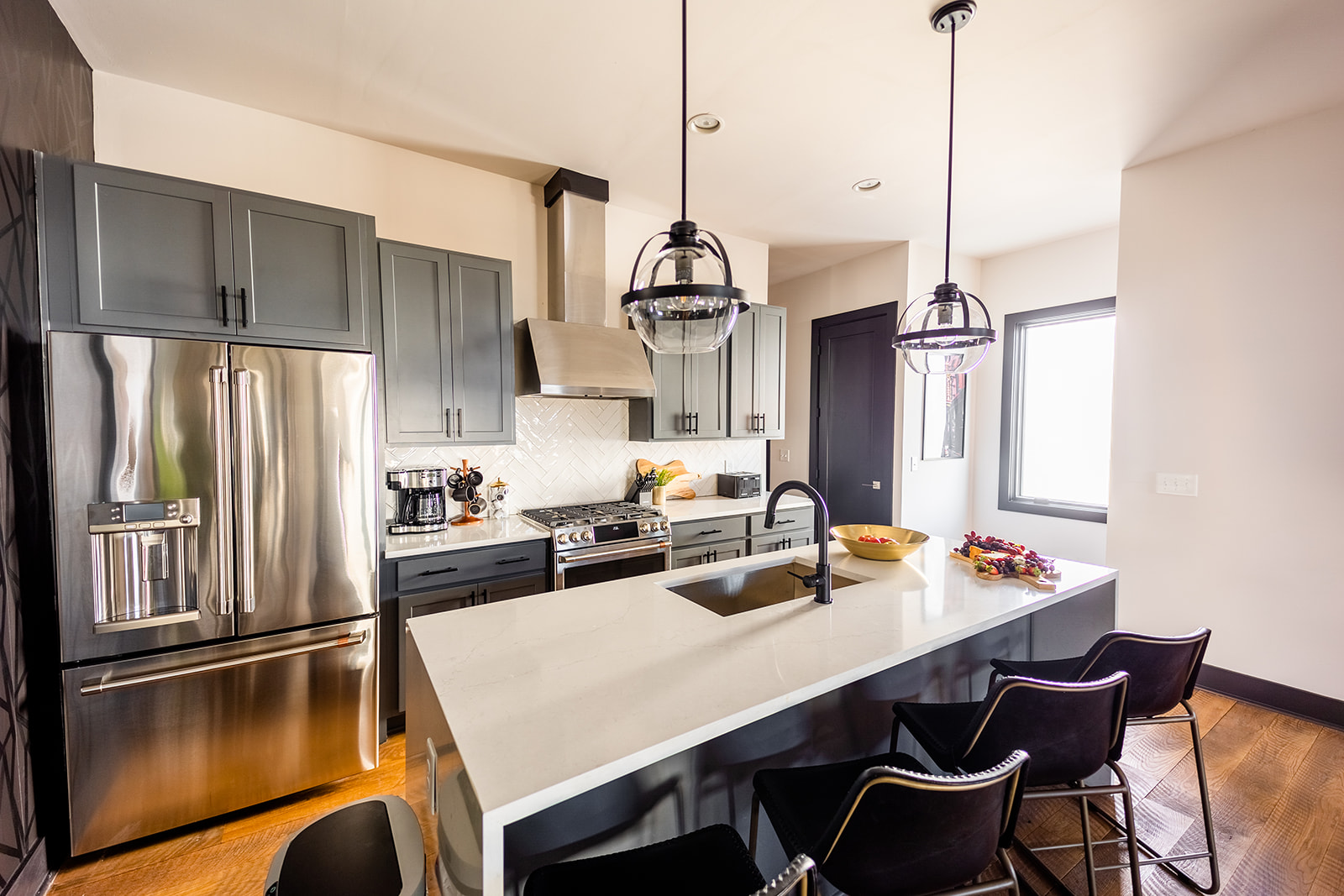 Bright open kitchen with professional stainless steel appliances and modern furnishes.