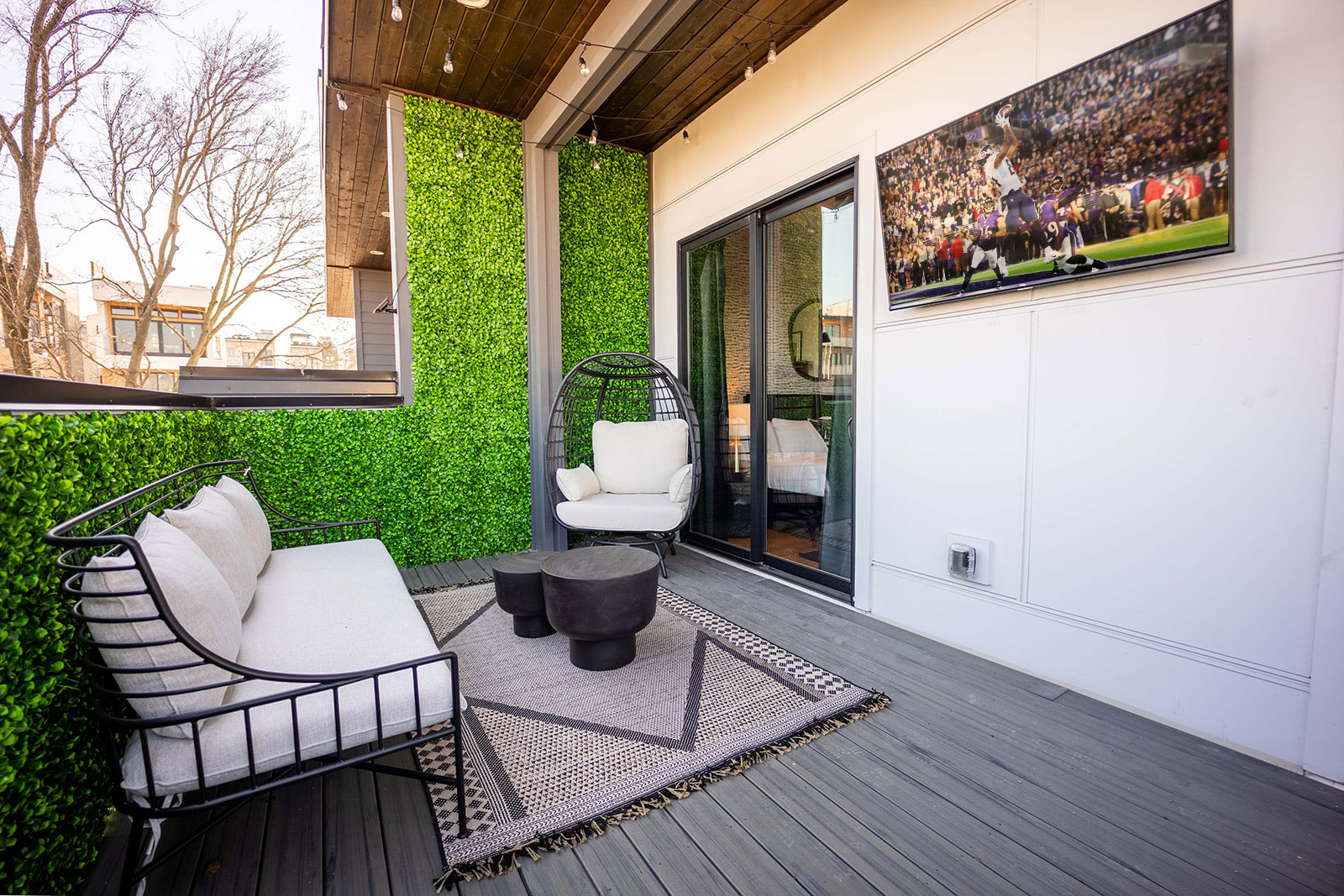Rooftop deck with designer furnishings, 60 in flatscreen TV, outdoor BBQ, and bistro lights.
