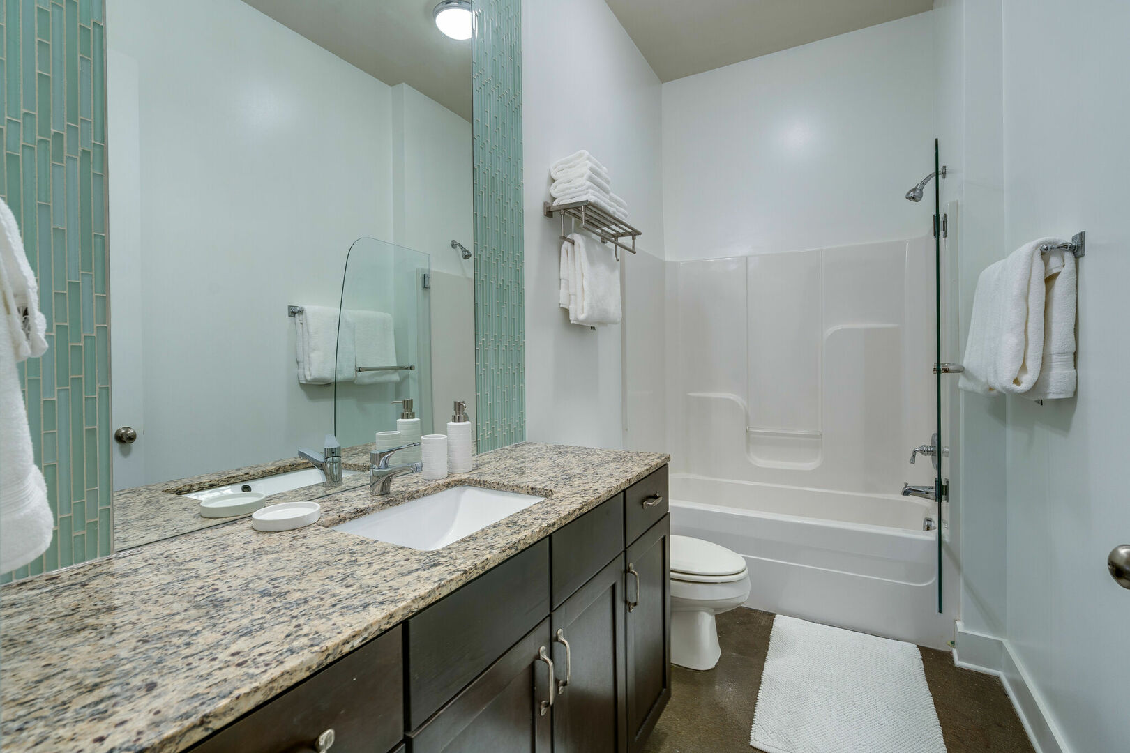 Spacious bathroom with large mirror and shower/tub combo.