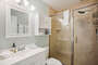 Spacious bathroom counter and shower with a vanity mirror and lots of storage you can use.