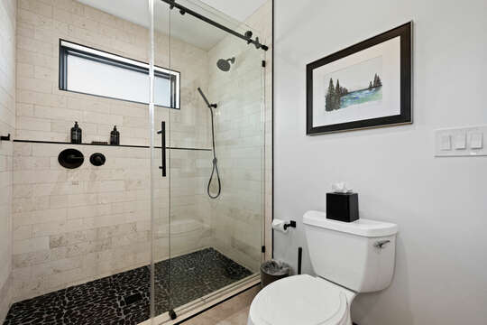 Downstairs en suite bathroom includes a large shower with pebble tiled floors