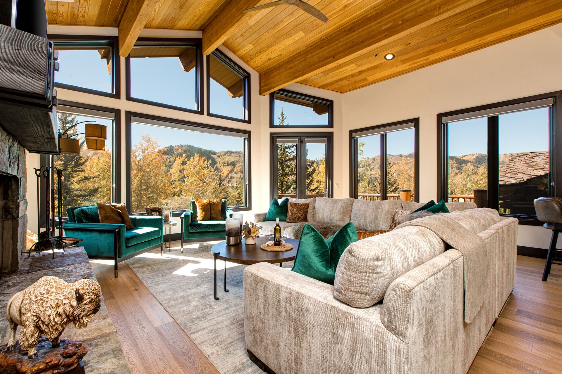 Living Room with plush sectional, gorgeous arm chairs, cozy gas fireplace, vaulted ceilings, floor to ceiling windows, Smart TV, and private deck access