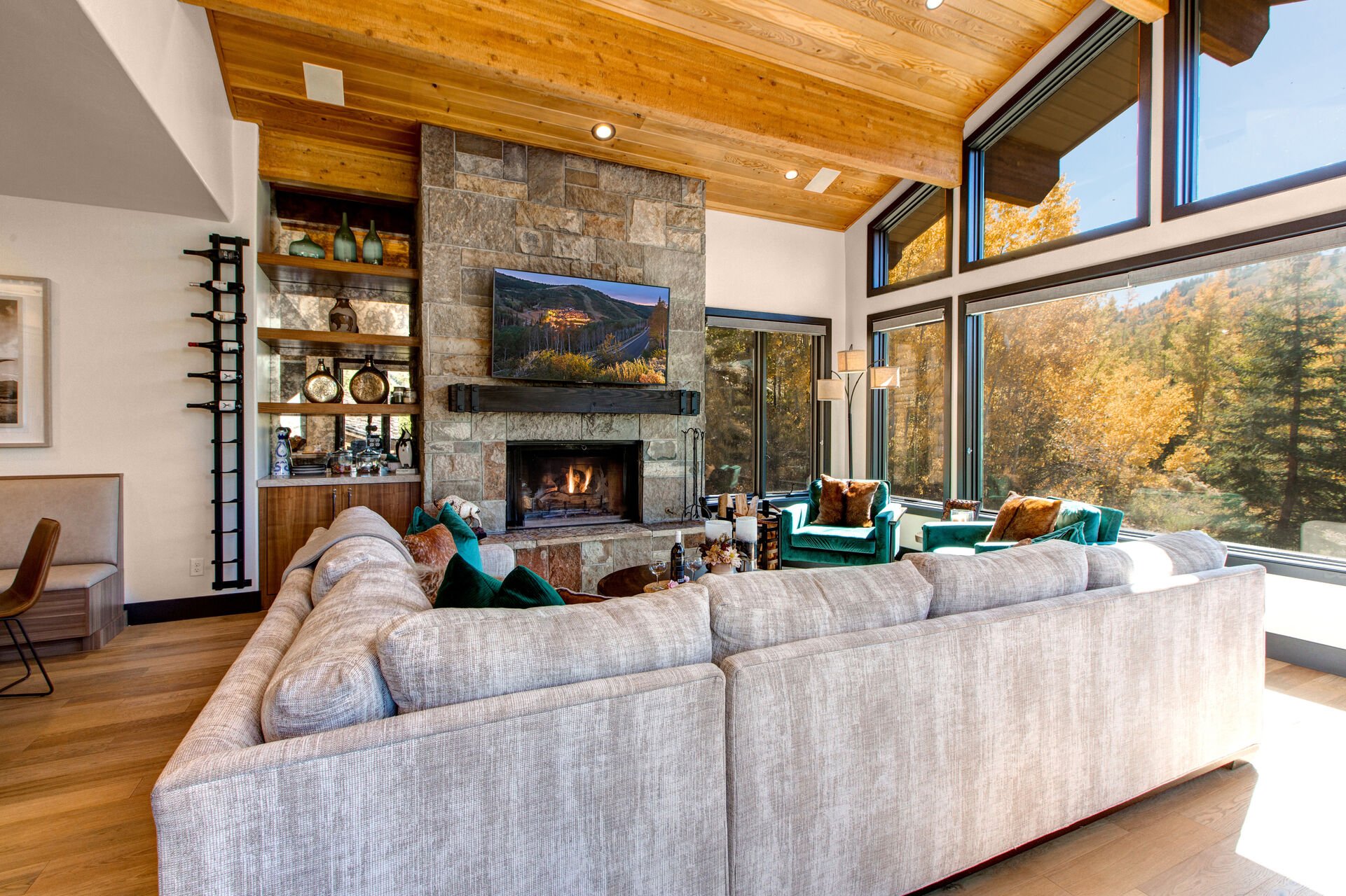 Living Room with plush sectional, gorgeous arm chairs, cozy gas fireplace, vaulted ceilings, floor to ceiling windows, Smart TV, and private deck access