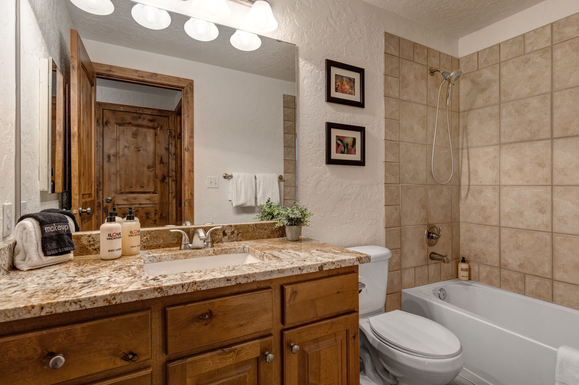 Full Shared Bath with a Granite Countertop Vanity and a Tub/Shower Combo