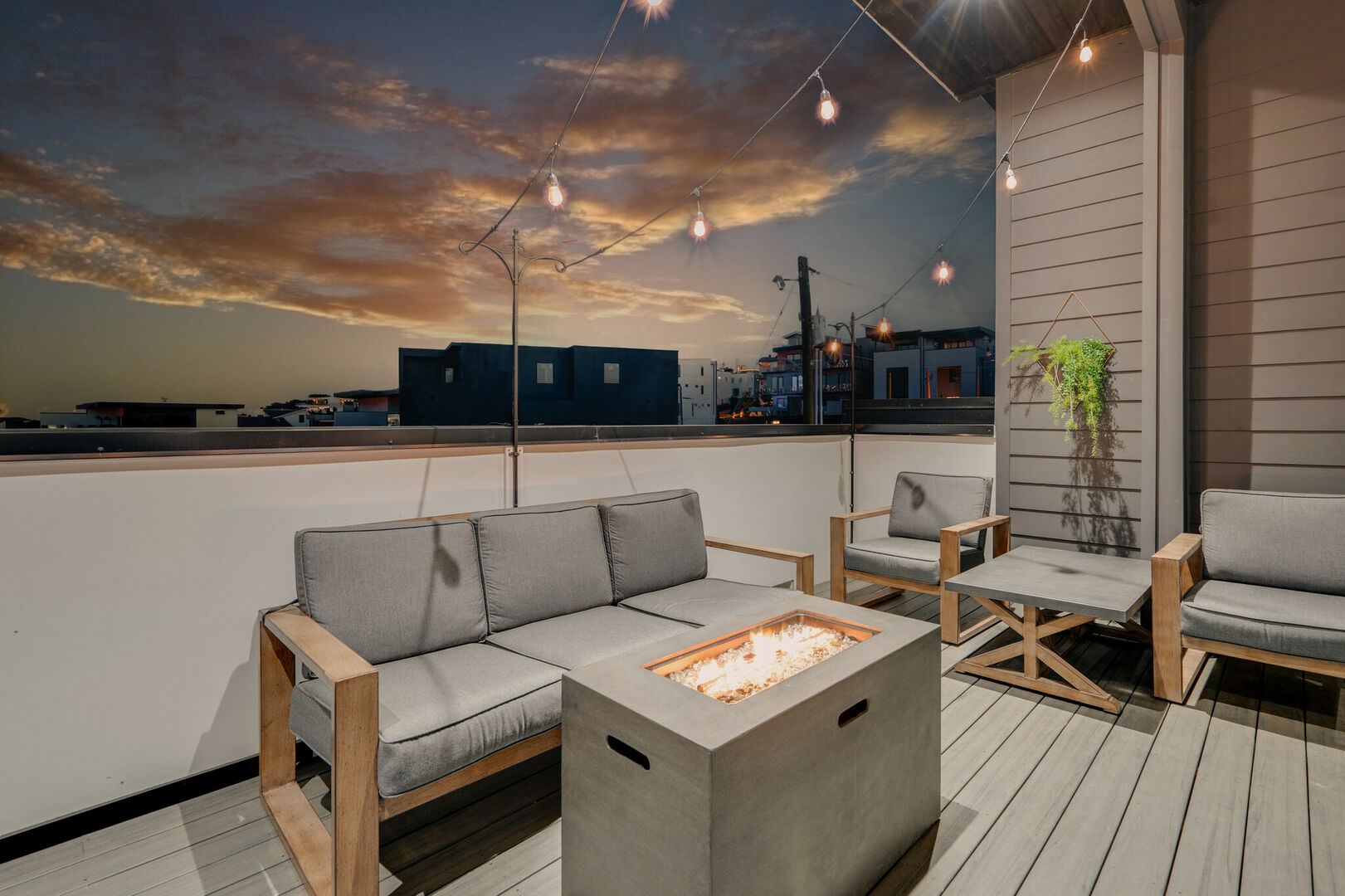 2nd unit: Rooftop patio with fire pit, outdoor bbq grill and lounge area draped in bistro lights.