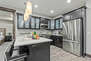 Fully equipped kitchen space features stainless steel Viking appliances, stone countertops, and bar seating for four