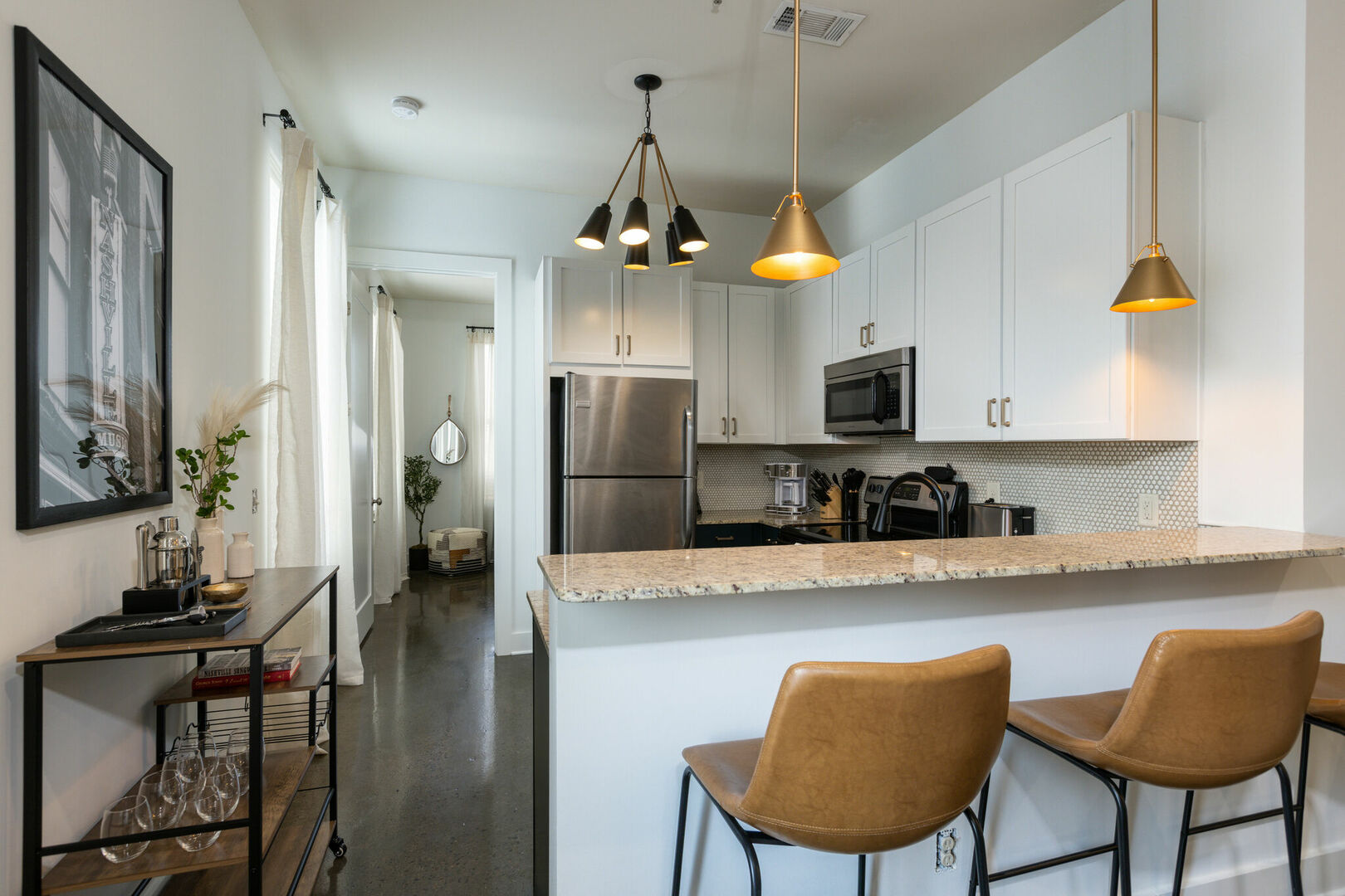 Fully equipped kitchen with stainless steel appliances, granite counter tops, breakfast bar seating, and stocked with your basic cooking essentials.