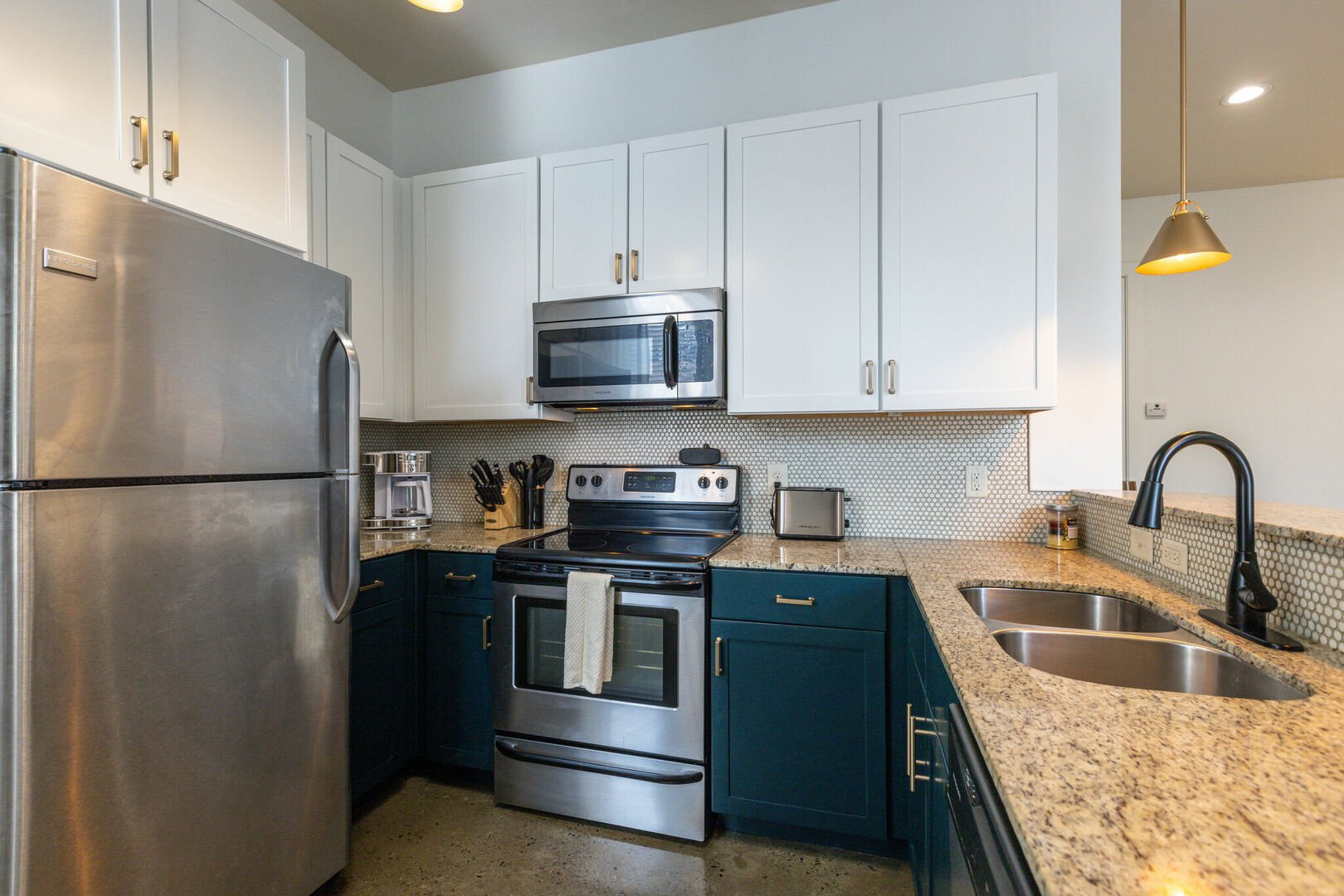 Fully equipped kitchen with stainless steel appliances, granite counter tops, breakfast bar seating, and stocked with your basic cooking essentials.