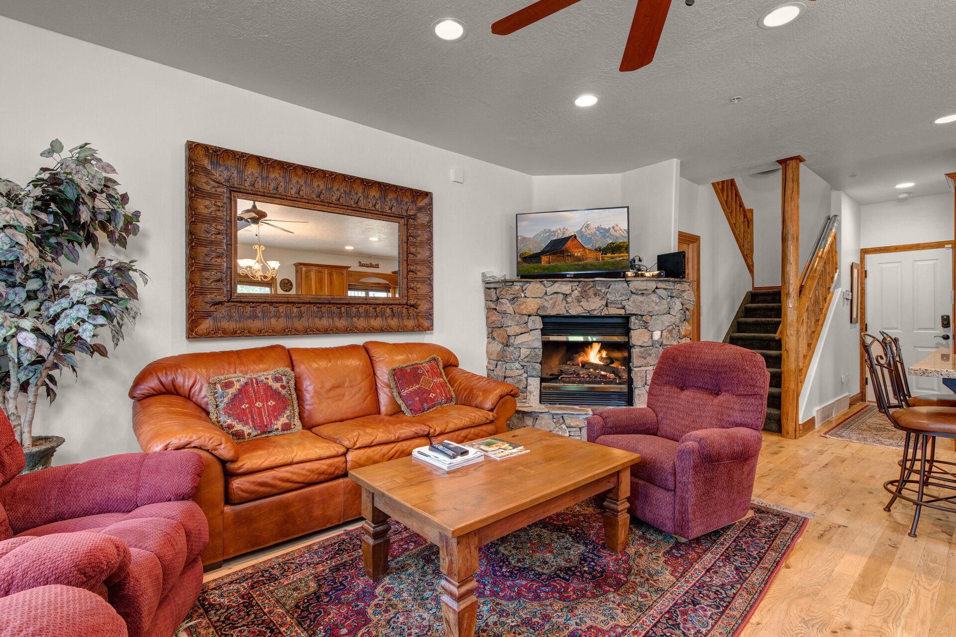 Living Room with plush leather sleeper sofa, reclining arm chairs, gas fireplace, smart TV, and beautiful natural light