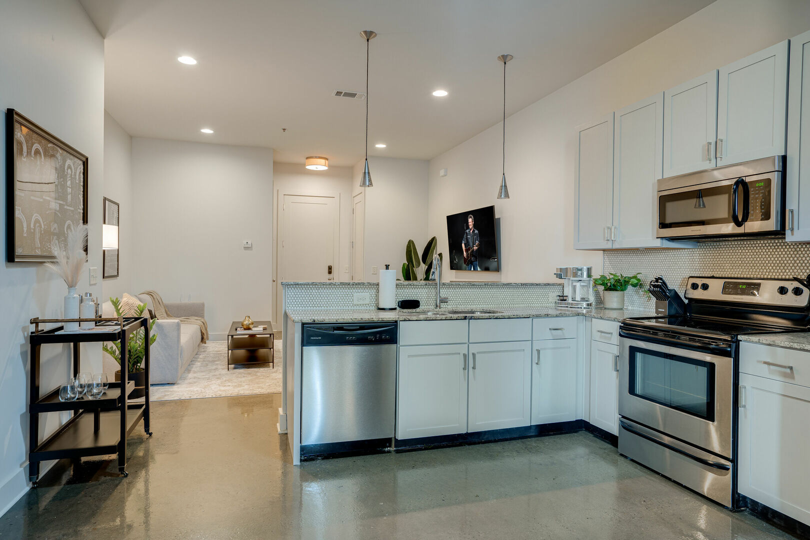Fully equipped kitchen with stainless steel appliances, breakfast bar seating, and fully stocked with your basic cooking essentials.