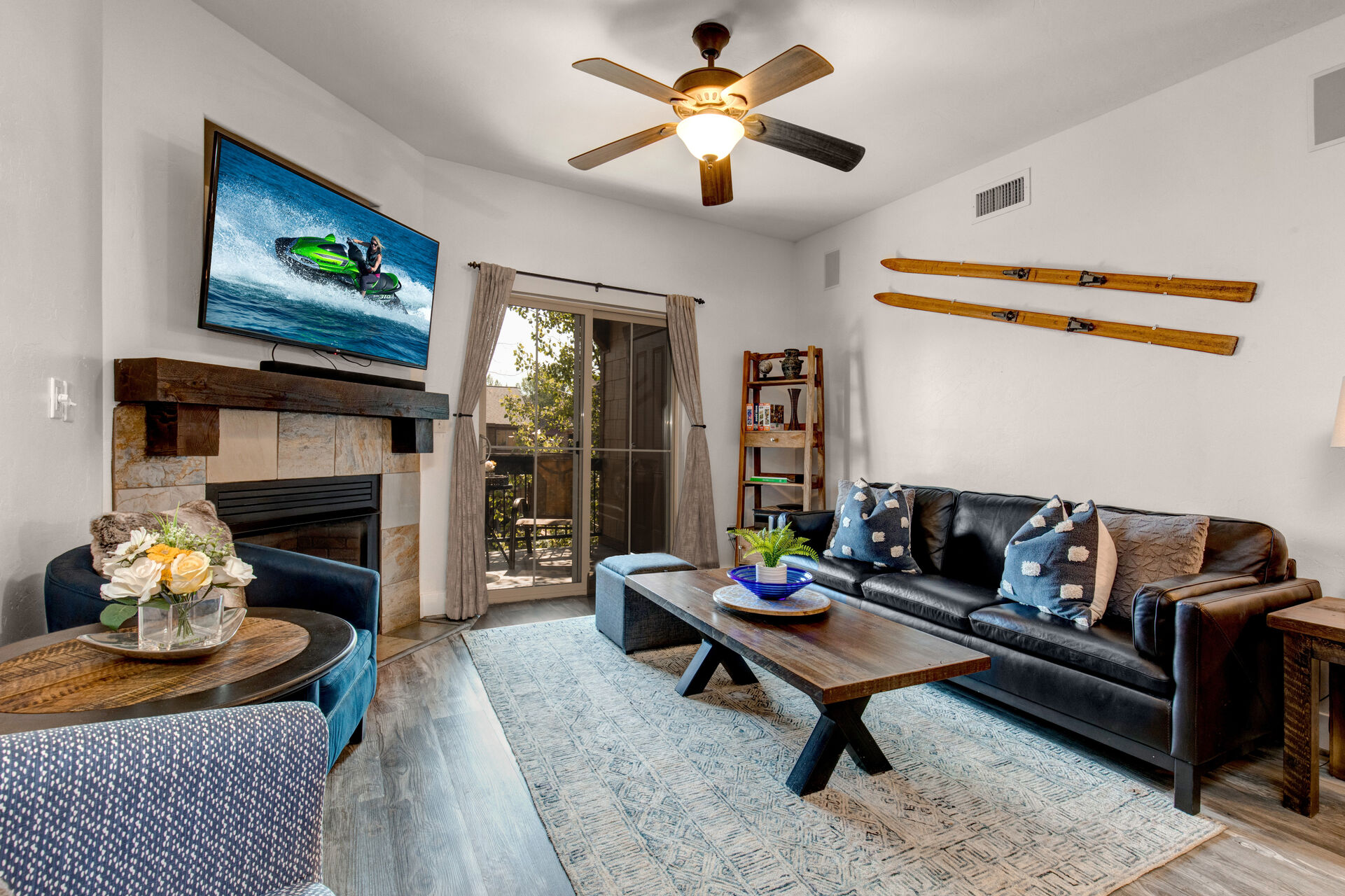 Living Room with gorgeous leather sofa, plush arm chairs, gas fireplace, smart TV, and private deck access