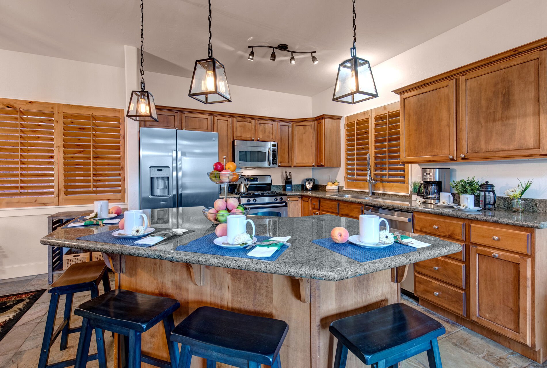Fully Equipped Kitchen with beautiful stone countertops, stainless steel appliances, ice maker, and island seating for four