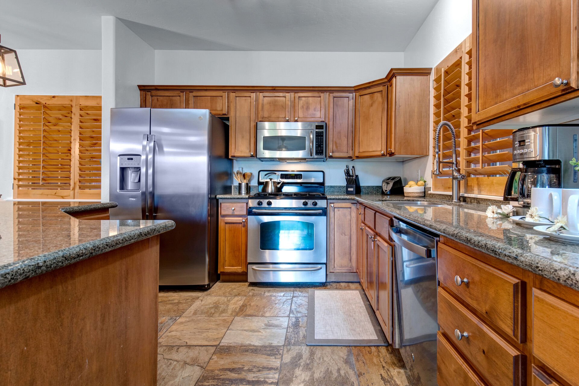 Fully Equipped Kitchen with beautiful stone countertops, stainless steel appliances, ice maker, and island seating for four