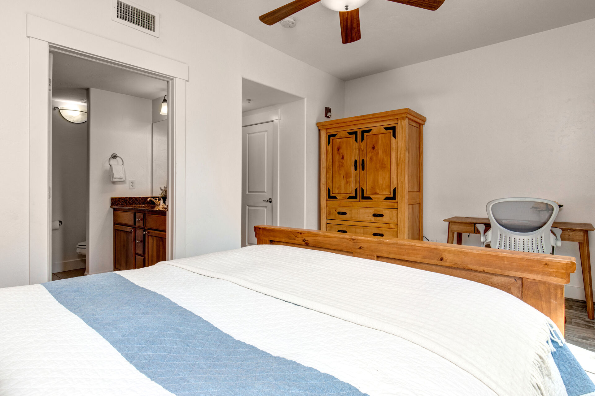 Master Bedroom with queen bed, private balcony, smart TV, work desk, and en suite bathroom