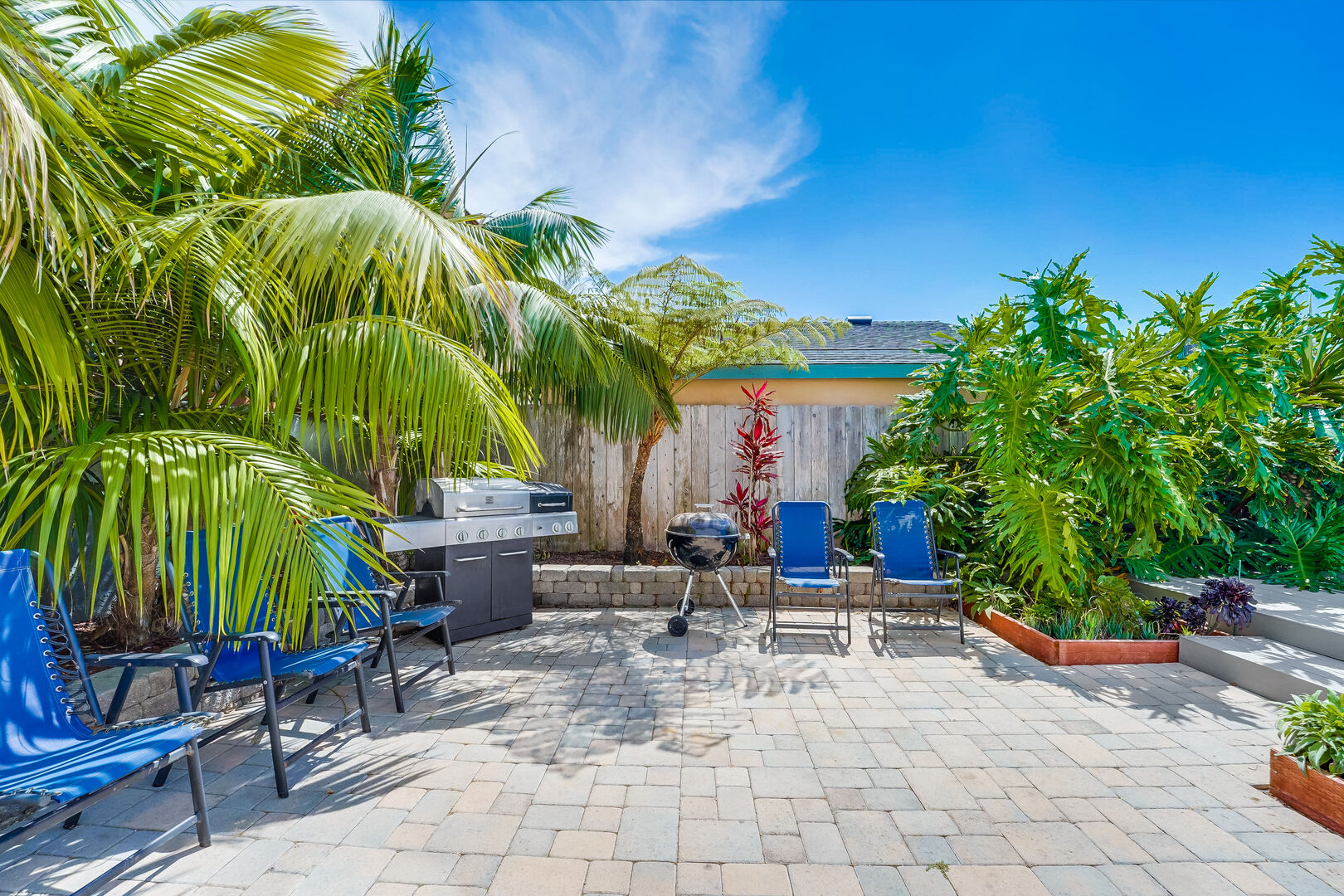 Backyard patio has a large, propane grill and smaller BBQ